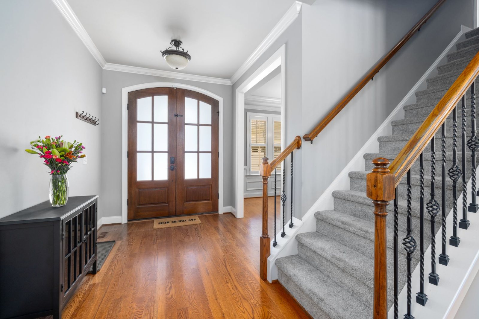 A carpeted staircase in a home, the runner clean right up to the edges against a painted baseboard, daylight from a landing window